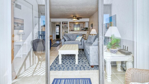 A living room with a sofa, coffee table, and a dining area with a table and chairs.