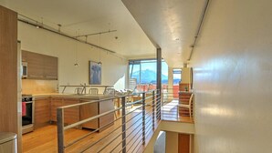 A modern kitchen with wooden cabinets, a stainless steel stove, and a large island.