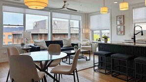 Une cuisine moderne avec un coin repas, de grandes fenêtres et un ventilateur de plafond.