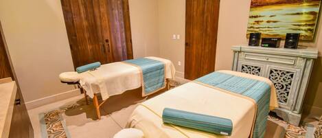 A hotel room with two beds, a massage chair, a decorative cabinet, and a wall-mounted air conditioner.