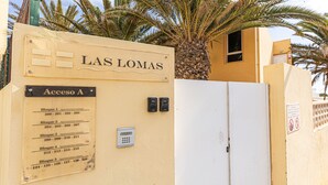A building entrance with a sign reading "LAS LOMAS" and a directory listing apartment numbers for blocks 1-5. - Private Terrace Home - Pool - Wifi (Costa Calma)