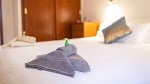 A neatly made bed with a folded towel and a decorative item on it. - Private Terrace Home - Pool - Wifi (Costa Calma)