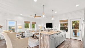 Amplia sala de estar con un sofá grande, una mesa de comedor y una isla de cocina.