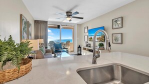 A modern kitchen with a large sink, a ceiling fan, and a view to the outside. - Sunrise gulf view/beach front condo! Enjoy one free beach chair set up each day (Destin)