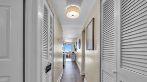 A hallway with white doors, a wooden floor, and a ceiling light. - Sunrise gulf view/beach front condo! Enjoy one free beach chair set up each day (Destin)