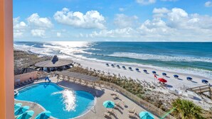 A resort with a swimming pool, beach umbrellas, and a view of the ocean. - Sunrise gulf view/beach front condo! Enjoy one free beach chair set up each day (Destin)