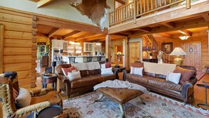L’intérieur de cette vaste cabane en rondins comprend un grand salon, un coin repas et une cuisine.