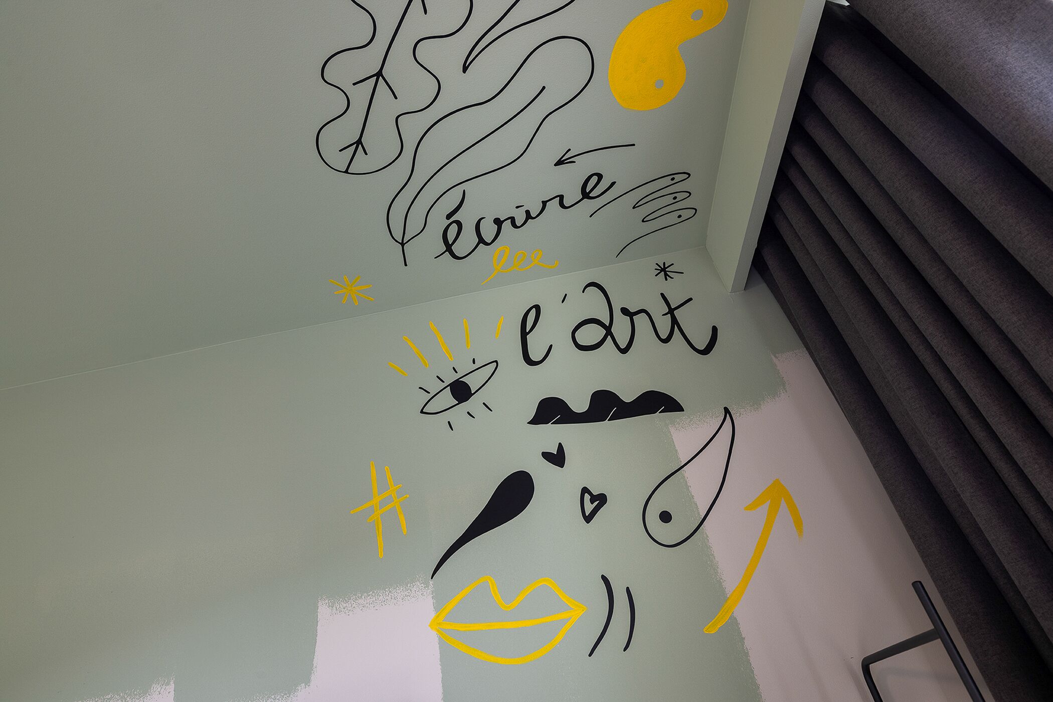 A wall with various hand-drawn symbols and text, including a heart, a fish, and the word "l'art".