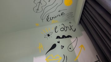 A wall with various hand-drawn symbols and text, including a heart, a fish, and the word "l'art".