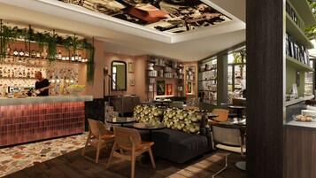 Zona de bar moderna con un cantinero, un espacio de estar con un sofá y sillones, y una estantería llena de libros y adornos.