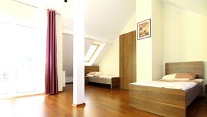 Un dormitorio con una cama de madera, una cama más pequeña y un tragaluz.
