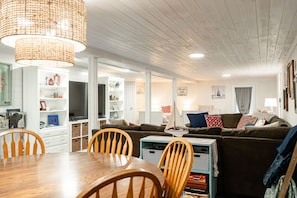 Relax in this spacious living area with a comfortable sofa, dining table, and TV.