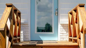A wooden staircase leading to a door with a glass panel, white brick walls, and a blue door. - POOL, HOT TUB, PET FRIENDLY FENCED IN YARD RETREAT CLOSE TO LAKE MICHIGAN!!! (Coloma)