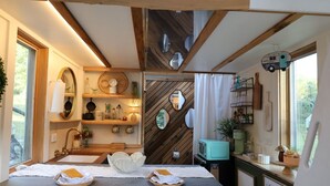 Una cocina rústica con vigas de madera, una radio antigua y un cartel de pizarra.