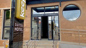 Una entrada de hotel moderna con un cartel que dice 'Keep Suites Hotel'.