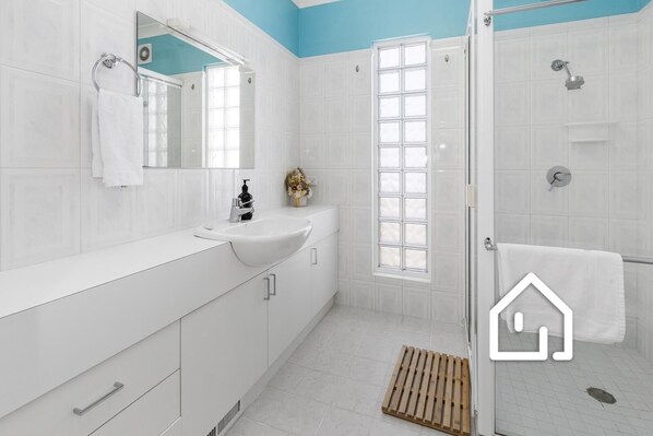 A modern bathroom with a white sink, mirror, and shower. - Bay Views at Tyrone Foreshore *1 NIGHT FREE* 200m Walk to Beach (Rye)