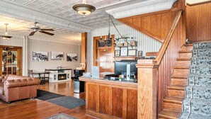 Uma sala de estar ampla com escada de madeira, área de jantar e cozinha com balcão.