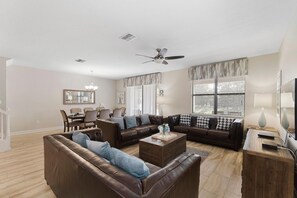 Relax in this spacious living room with a large sectional sofa, dining area, and flat-screen TV.