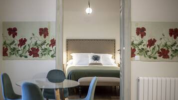Ein Schlafzimmer mit einem Bett, einem Tisch mit Stühlen und floraler Wandgestaltung.