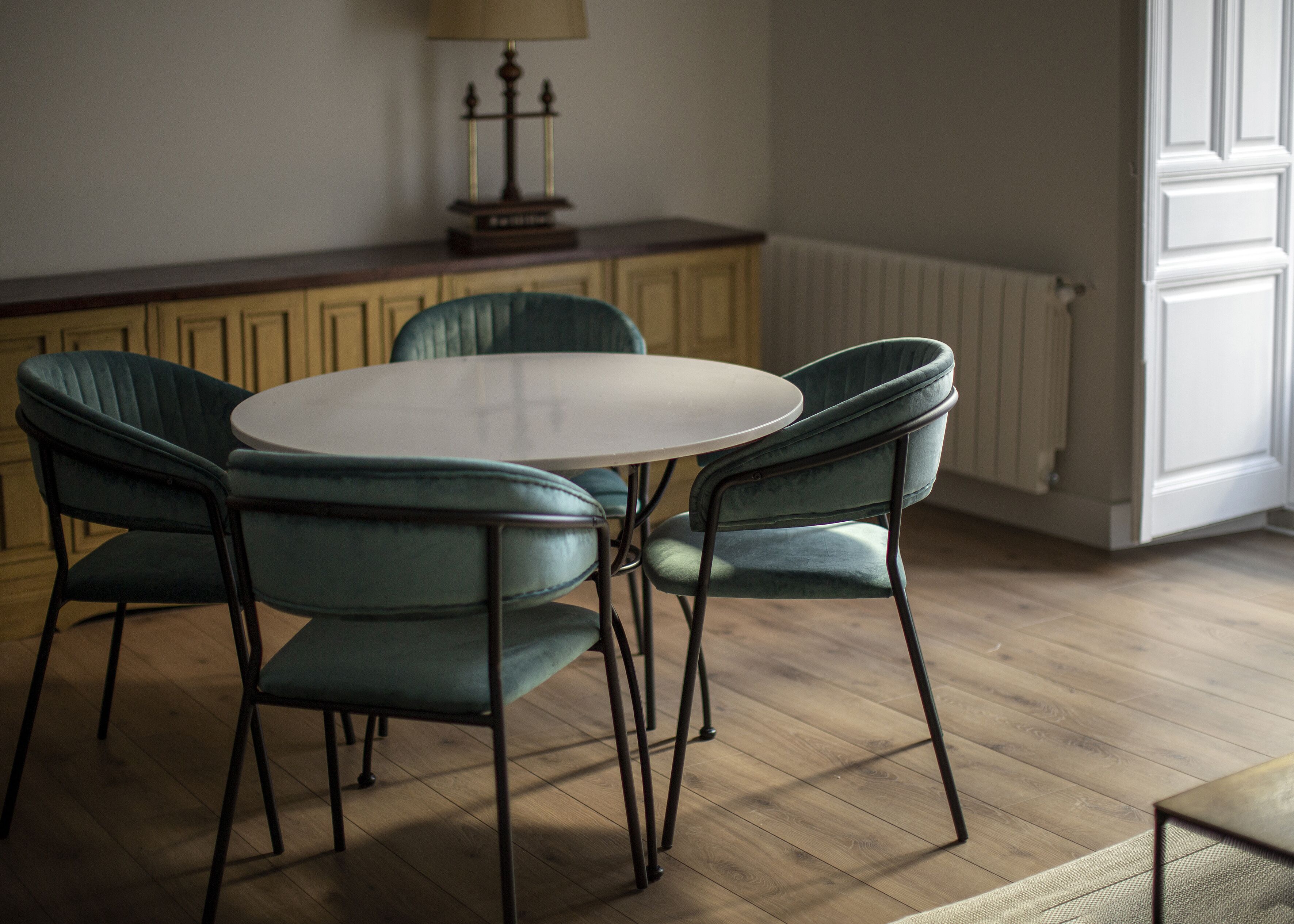 Un comedor con una mesa redonda y cuatro sillas.