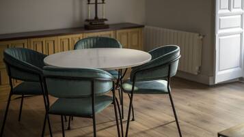 Un comedor con una mesa redonda y cuatro sillas.