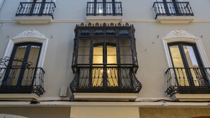 A building with ornate balconies, large windows, and a number '20' sign.