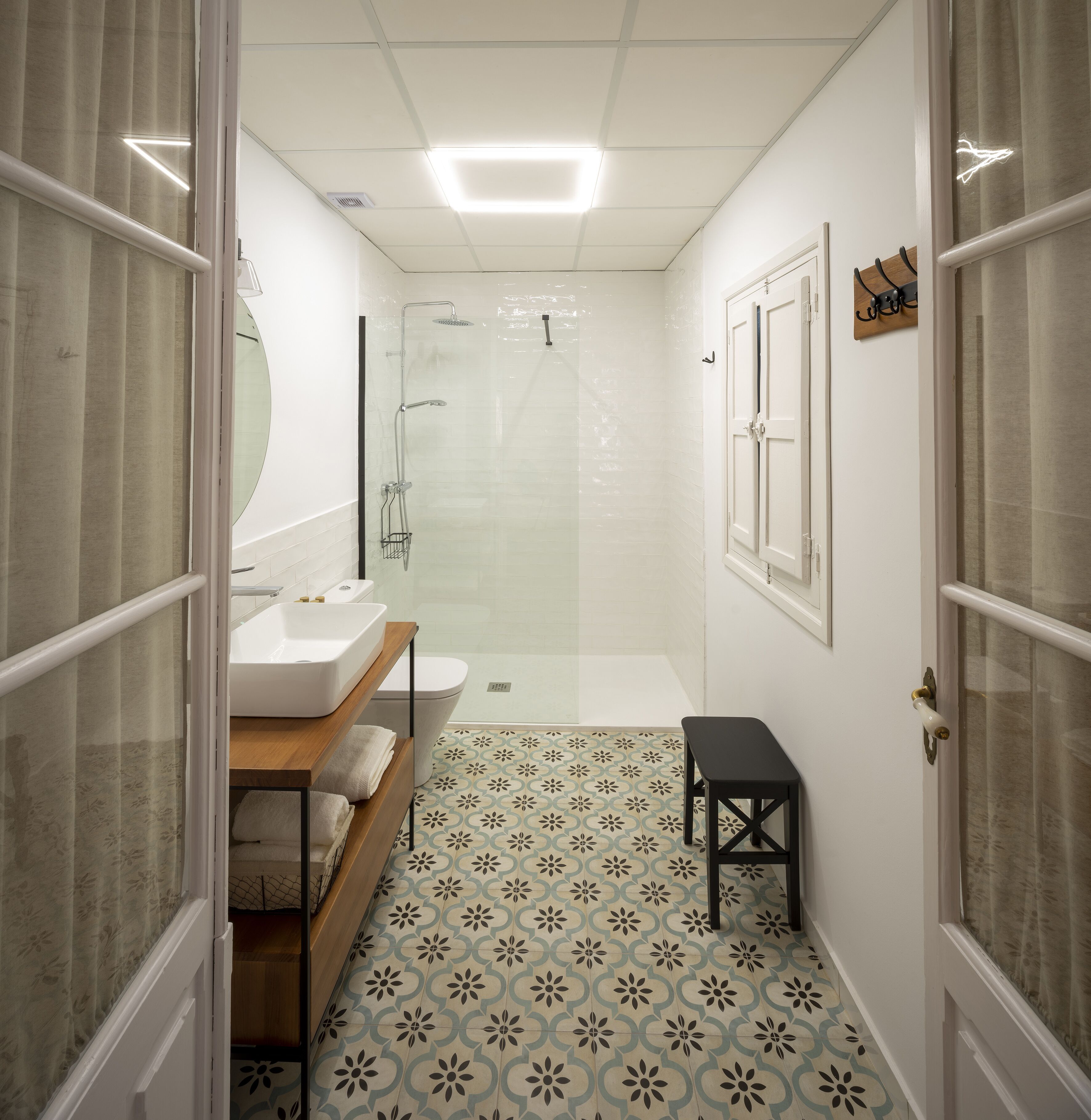Une salle de bain avec douche, toilettes et lavabo.