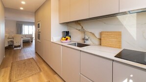 A modern kitchen with a marble backsplash, stainless steel appliances, and a wooden cutting board. - Exclusive holiday apartment in Colonia Sant Jordi for max. 4 people (Colonia Sant Jordi)