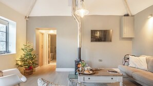 A cozy living room with a fireplace, a Christmas tree, and a comfortable seating area. - 2 bedroom accommodation in Northrepps (Northrepps)