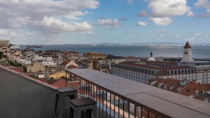Un paysage urbain avec vue sur la mer et une tour de l’horloge imposante.