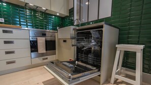 A modern kitchen with a built-in oven, a dishwasher, and a wooden countertop.