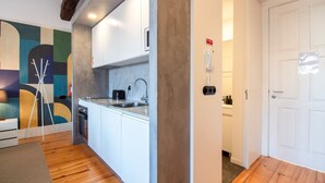 Une cuisine moderne équipée d’un évier, d’un grille-pain et d’un téléphone. On y trouve une porte avec un panneau indiquant la sortie de secours.