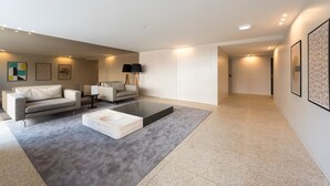 A modern living room with a grey carpet, two sofas, a coffee table, and a black floor lamp.