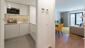 A modern apartment with a kitchen, dining area, and living room.