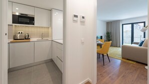 A modern apartment with a kitchen, dining area, and living room.