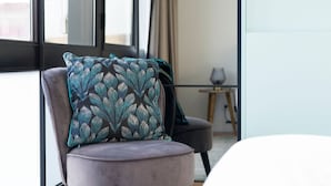 A chair with a patterned cushion in a modern room with large windows and a minimalist design. - Wohaza Flat w/ Parking by LovelyStay (Porto)