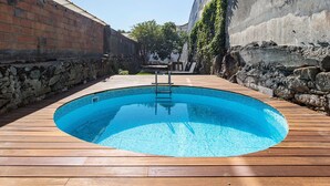 Une piscine rectangulaire entourée d’une terrasse en bois.