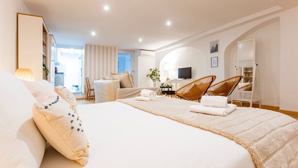 Une chambre d’hôtel moderne avec un grand lit, un bureau et une télévision.