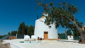 A white, round building with a door and windows, surrounded by trees and a swimming pool. - Bee Moinho - One Bedroom House, Sleeps 3 (Mafra)