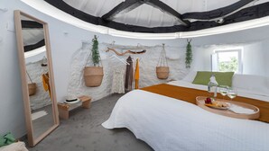 A bedroom with a bed, a bedside table with a tray of food and drinks, a hanging plant, and a mirror. - Bee Moinho - One Bedroom House, Sleeps 3 (Mafra)