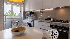 Eine moderne Küche mit Waschmaschine, Kaffeemaschine und Herd.