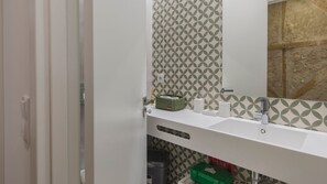 Ein Badezimmer mit einem weißen Waschbecken, einem Spiegel und Wandpapier mit Muster.