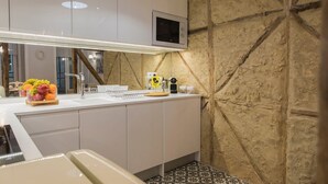 A modern kitchen with a built-in microwave, a sink, and a fruit bowl on the counter.