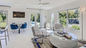 Ein modernes Wohnzimmer mit einem runden Couchtisch, blauen Sesseln und einem Deckenventilator.