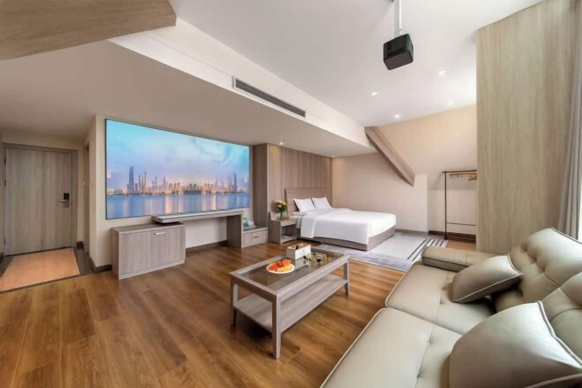 Une chambre d’hôtel moderne équipée d’un lit, d’une télévision, d’un canapé et d’une table à manger.