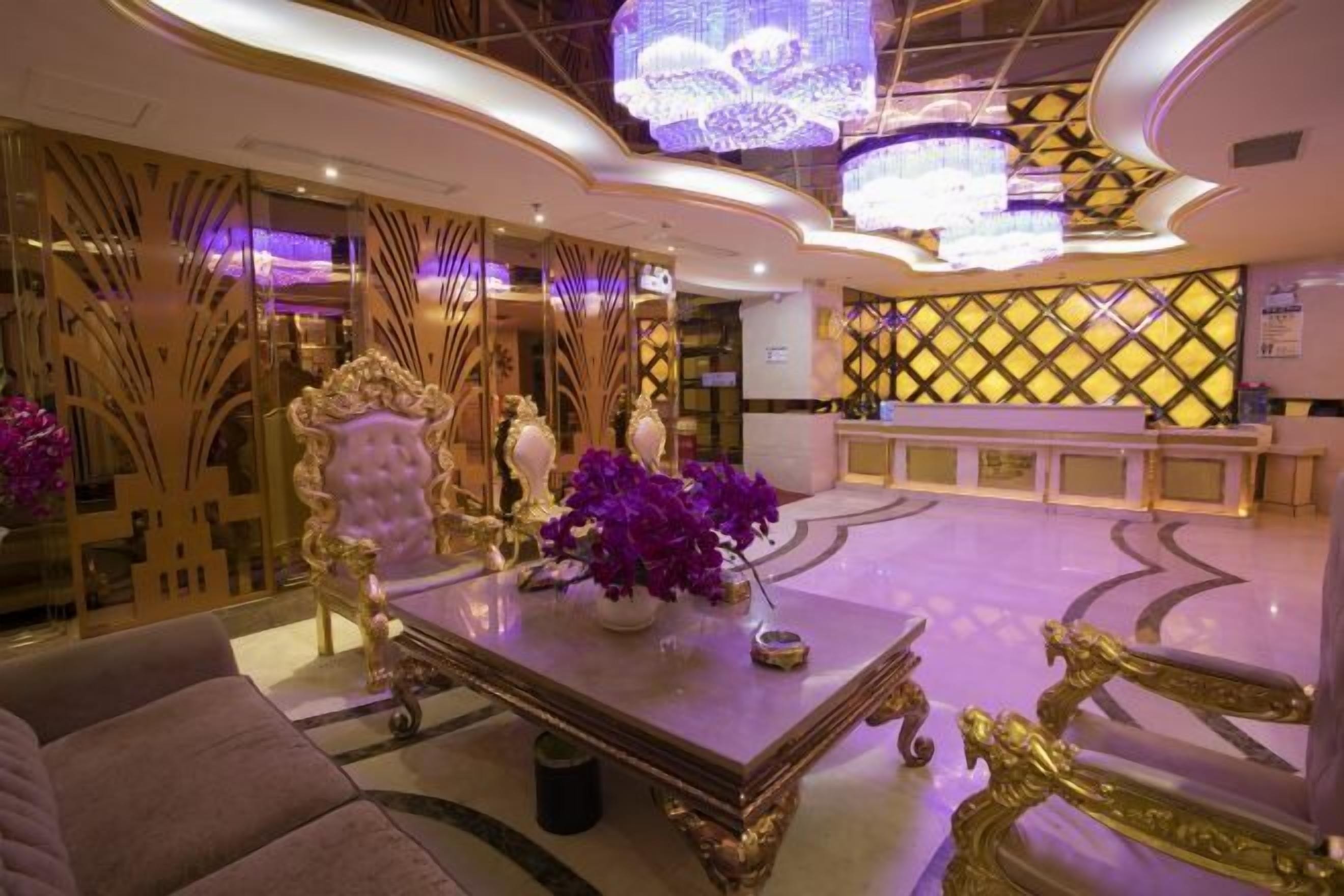 A luxurious lobby with ornate furniture, a reception desk, and decorative lighting.