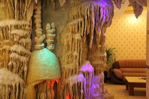 A room with a cave-like wall feature, a sofa, and a coffee table.