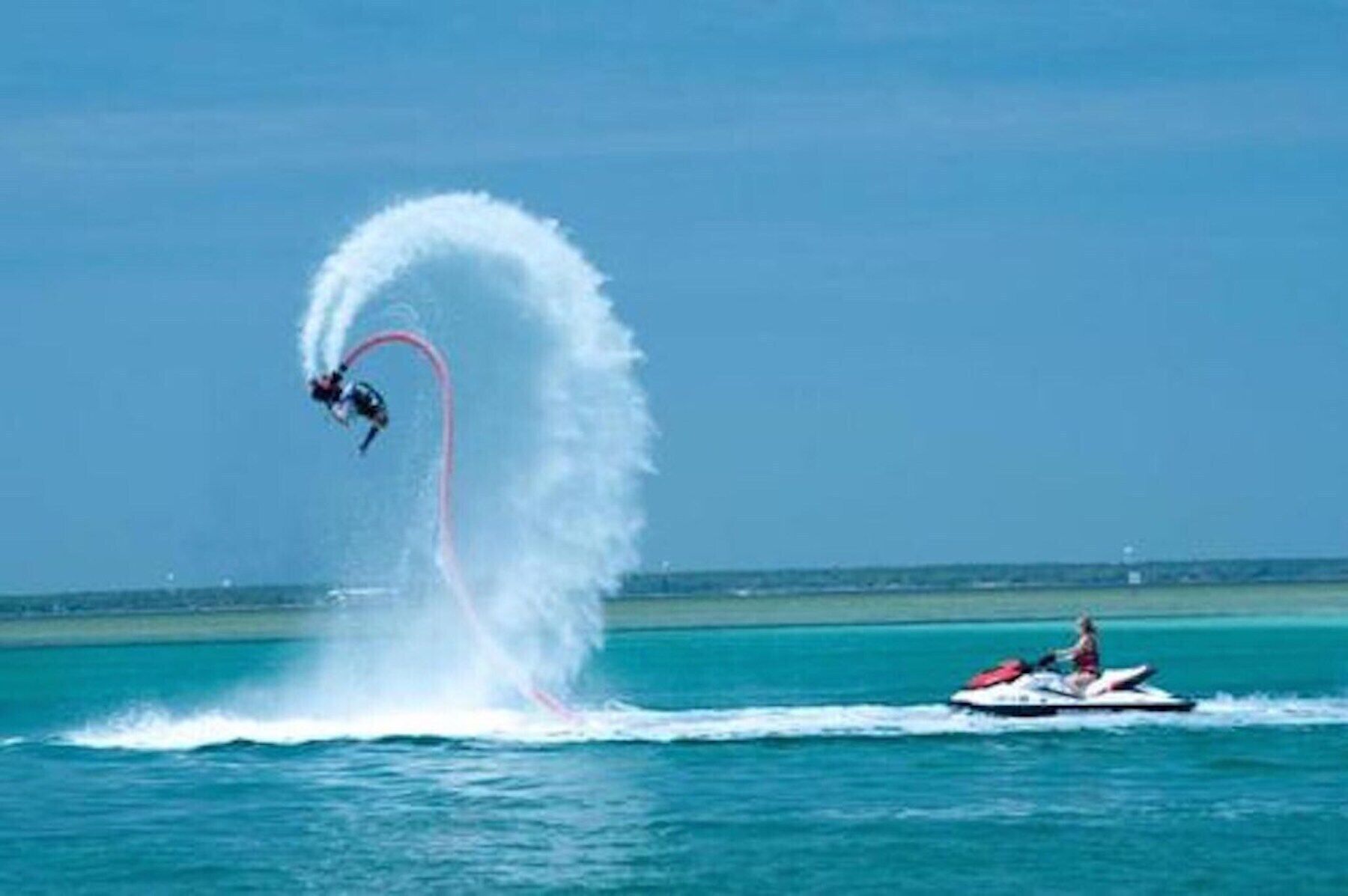 A jet ski performing a stunt with a wake behind it.