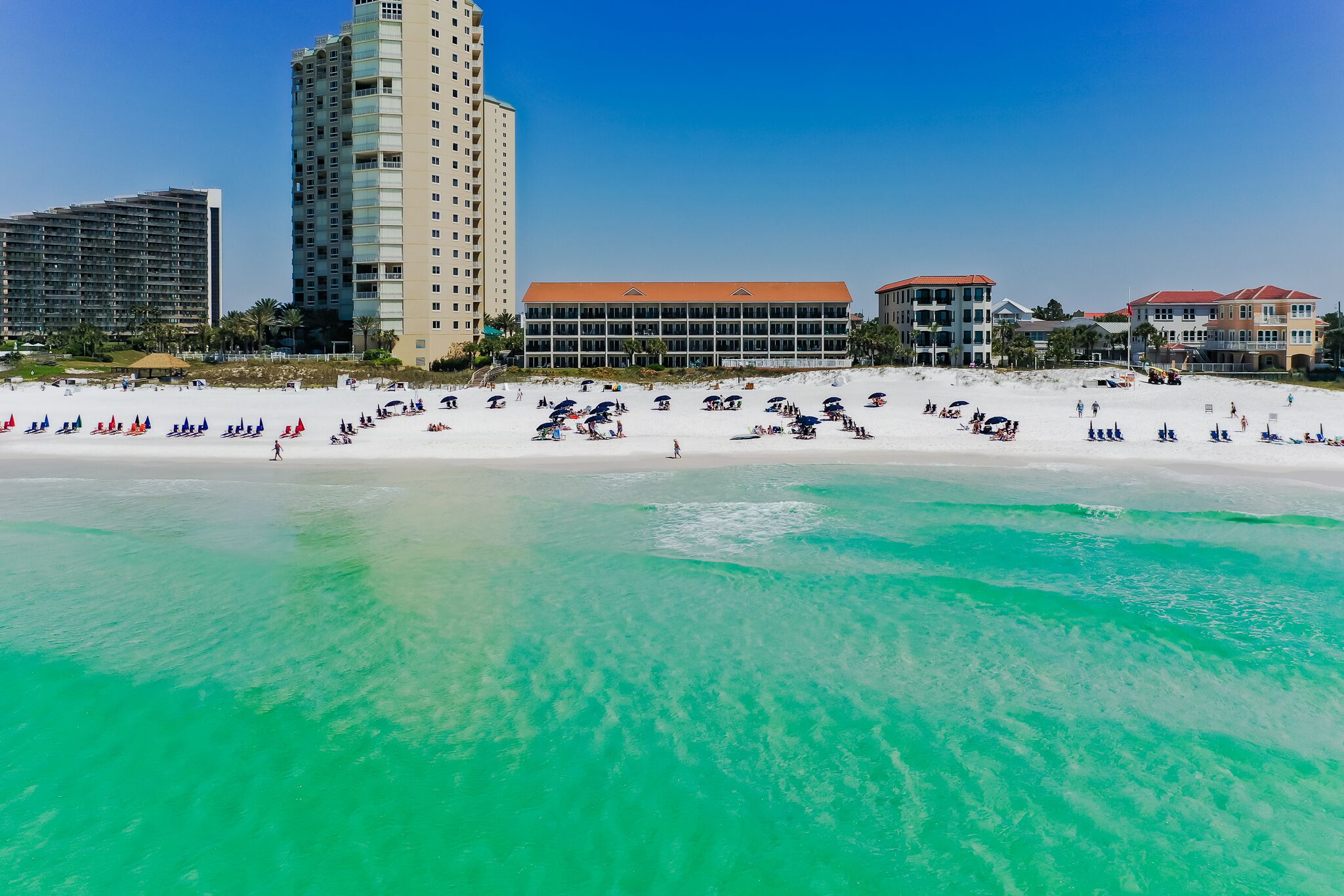 Una playa con un hotel al fondo.