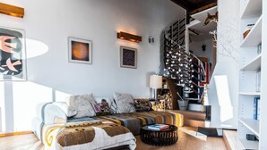 Un salon moderne avec un canapé, une table basse et un escalier au design original.